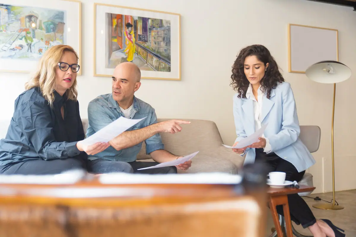 Family law attorneys meeting with a couple in a bright living room